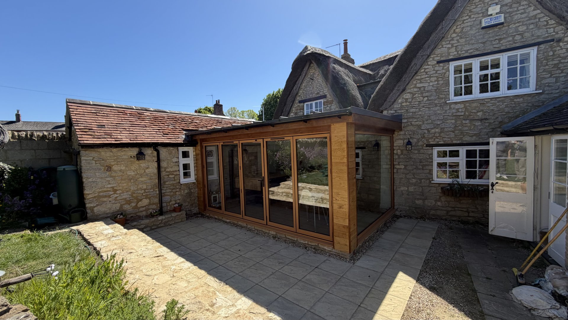 Contemporary kitchen extension with large windows and oak aluminium bi-fold doors in Castlethorpe